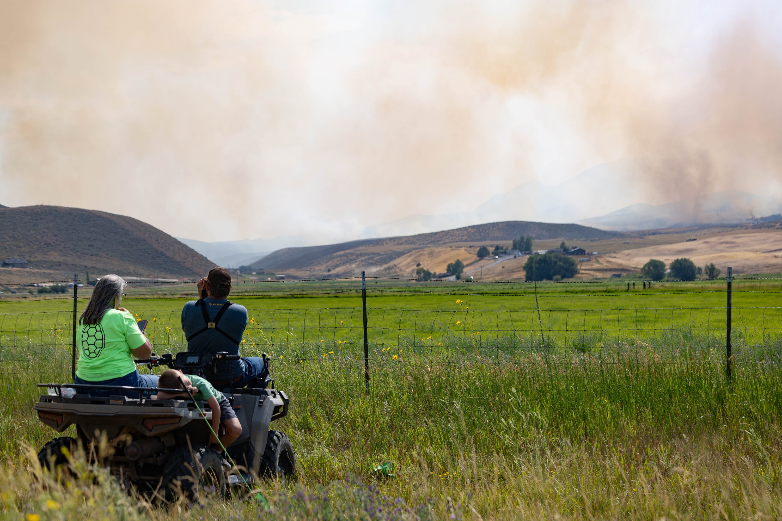 A family watches closely as a wildfire burns in Rocky Canyon near Henefer on Aug. 10.