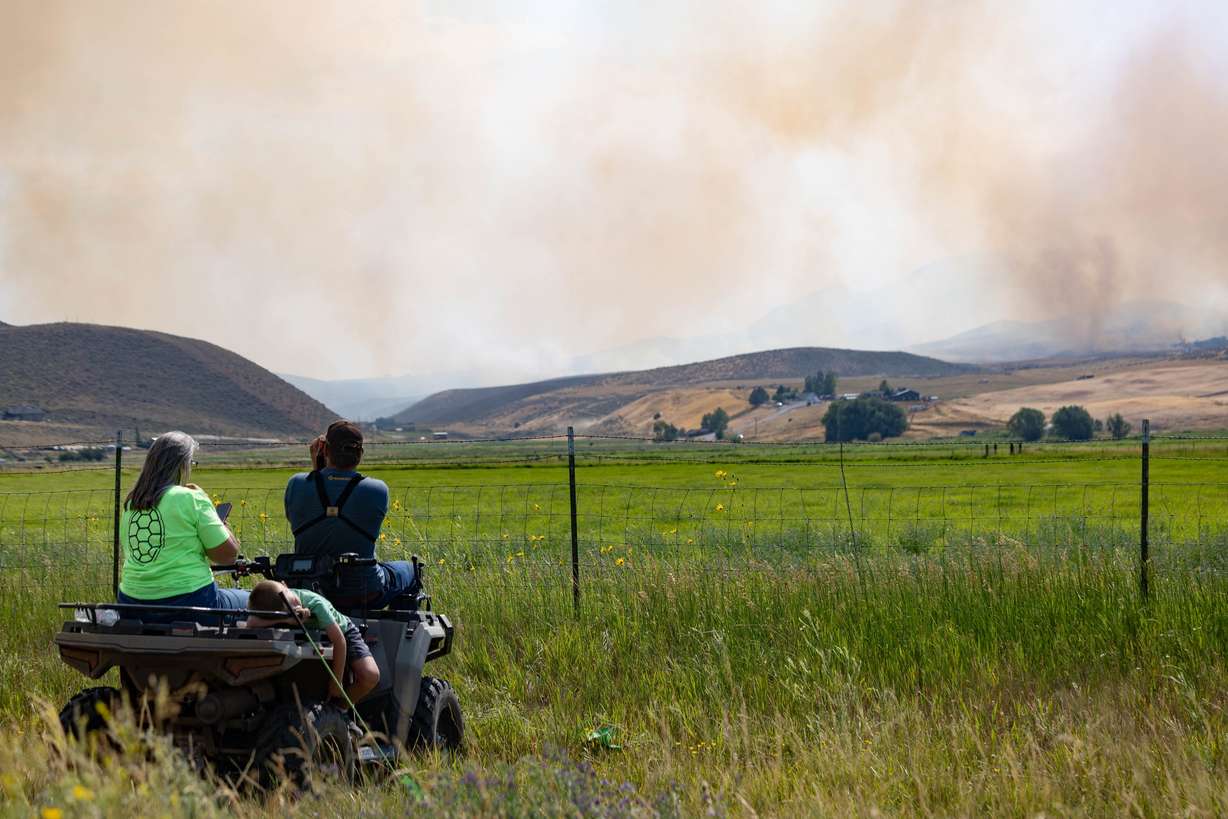 A family watches closely as a wildfire burns in Rocky Canyon near Henefer on Aug. 10.