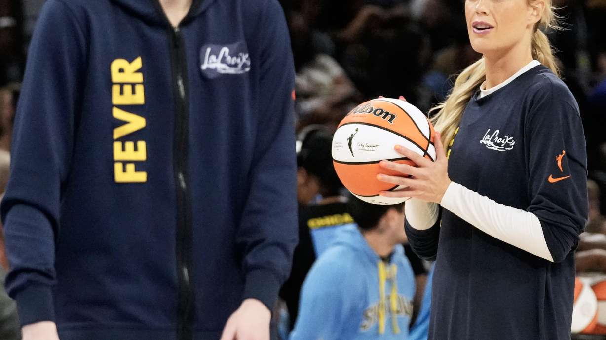 Indiana Fever guard Sophie Cunningham, right, warms up as guard Caitlin Clark, left, talks with teammates before a WNBA basketball game against the Chicago Sky, Sunday, Aug. 23, 2026, in Chicago.