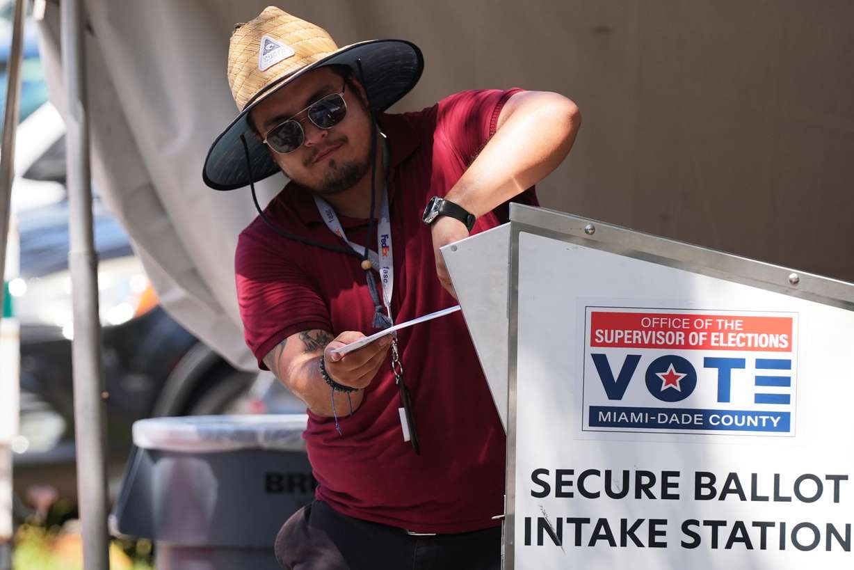 An election worker places a vote-by-mail ballot into a secure bin at the Miami-Dade County Supervisor of Elections Office during the Florida primary election in Doral, Fla., Tuesday, Aug. 18.
