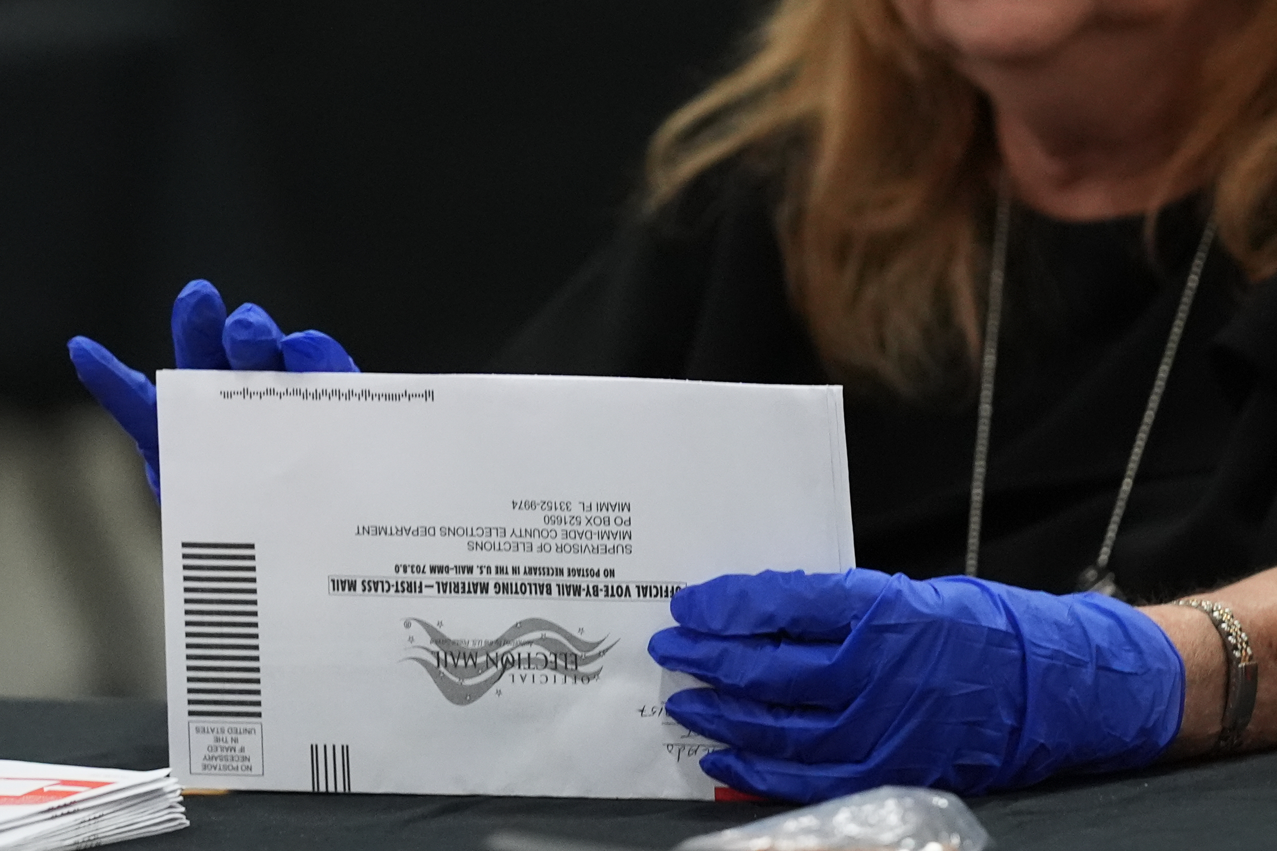 An election worker sorts vote-by-mail ballots at the Miami-Dade County Supervisor of Elections Office for the Florida primary election in Doral, Fla., Tuesday, Aug. 18.