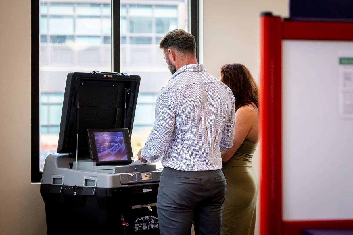 Voters put their ballots into a ballot-scanning machine during Utah’s primary election at the Lehi Civic Center on June 23.