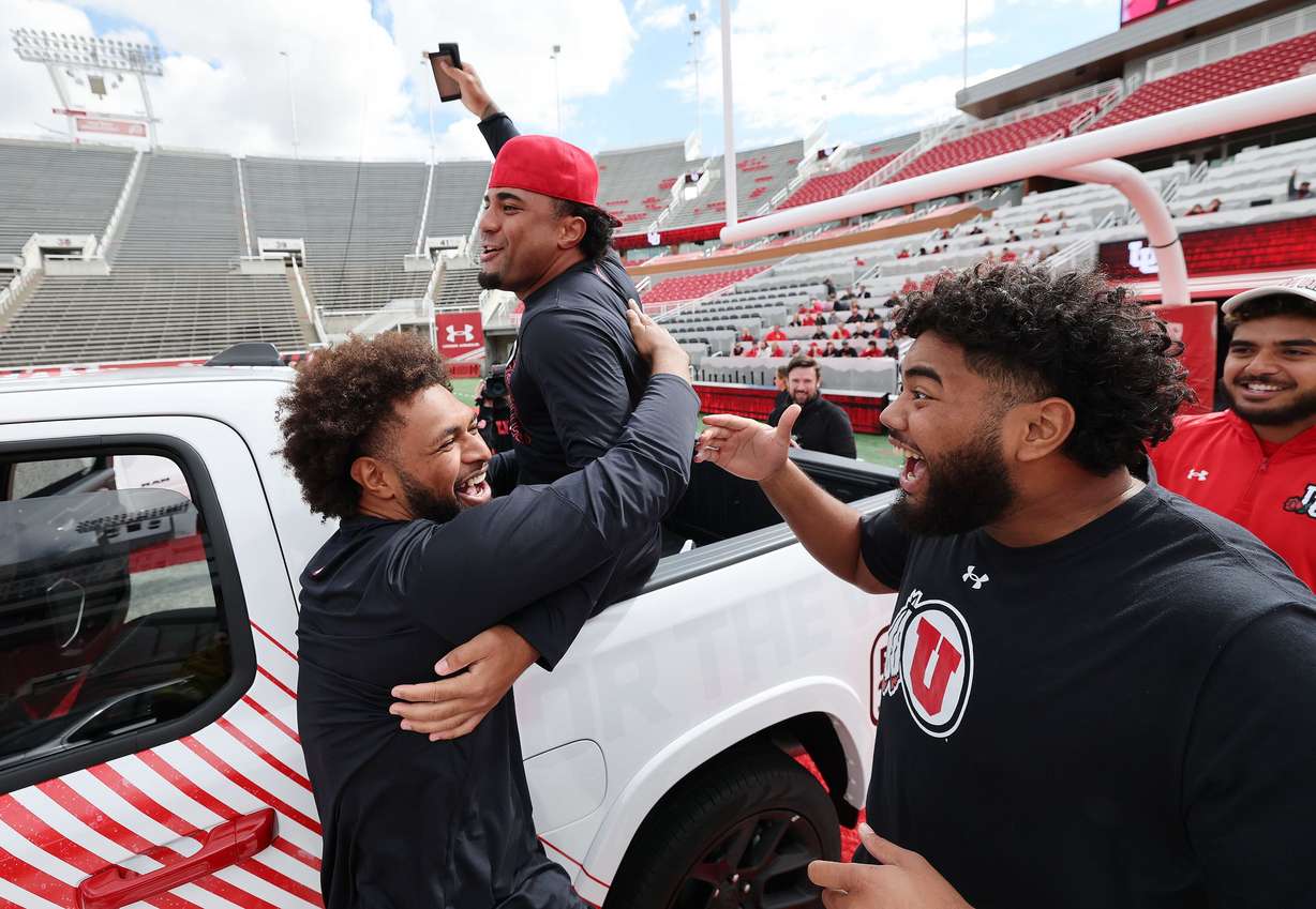 Utah Utes football scholarship players Levani Damuni, from left, Tevita Fotu and Solatoa Moea'i celebrate receiving a Dodge truck from the Crimson Collective during an NIL announcement at Rice-Eccles Stadium in Salt Lake City on Oct. 4, 2023.