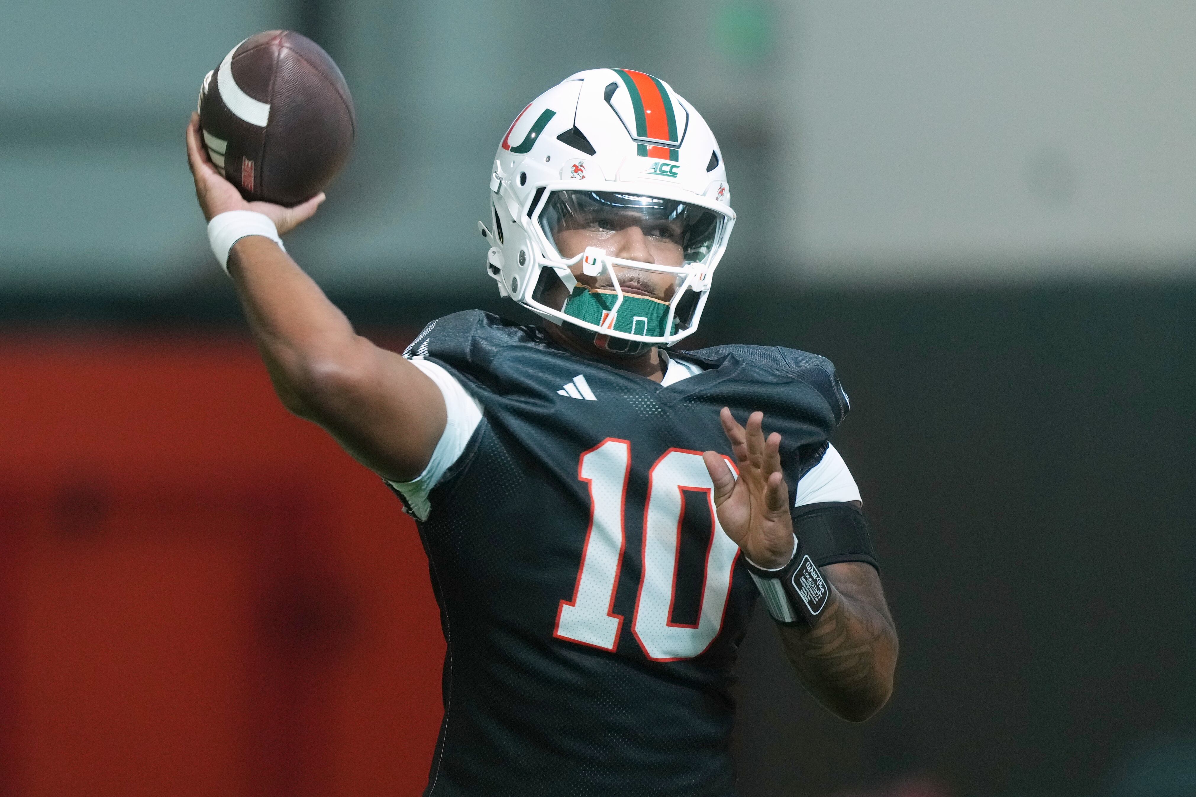 Miami quarterback Darian Mensah (10) throws a pass during a practice session at their training facility, Aug. 4, in Coral Gables, Fla.