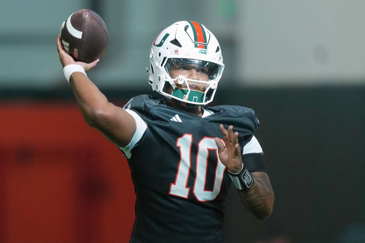Miami quarterback Darian Mensah (10) throws a pass during a practice session at their training facility, Aug. 4, in Coral Gables, Fla.