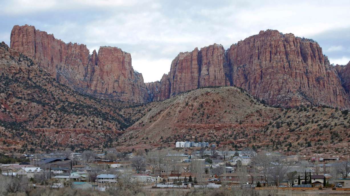 This photo shows Hildale, Utah, sitting at the base of Red Rock Cliff mountains, with its sister city, Colorado City, Ariz., in the foreground, Dec. 16, 2014.