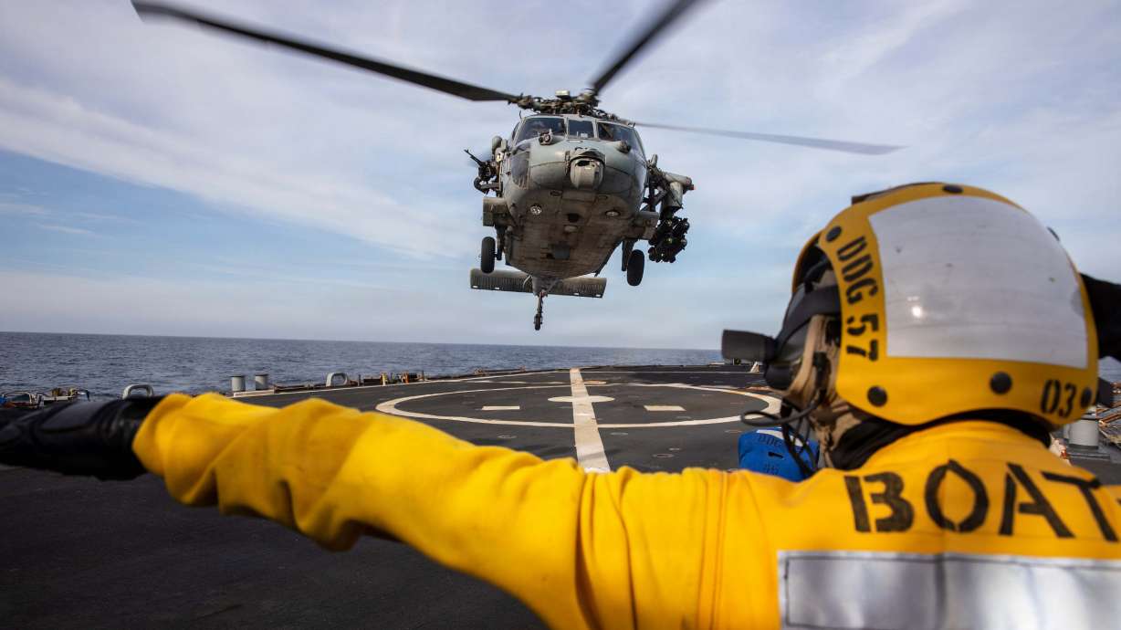 A U.S. Sailor signals to an MH-60S Sea Hawk helicopter on the flight deck of the USS Mitscher on April 15. Mitscher is deployed to the U.S. 5th Fleet area of operations to support maritime security and stability in the Middle East.