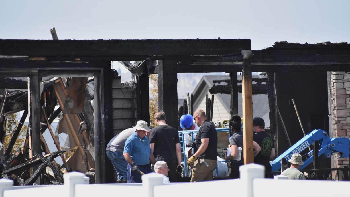 Investigators work at the scene Tuesday, where a family was killed and the house burned in Billings, Montana. .