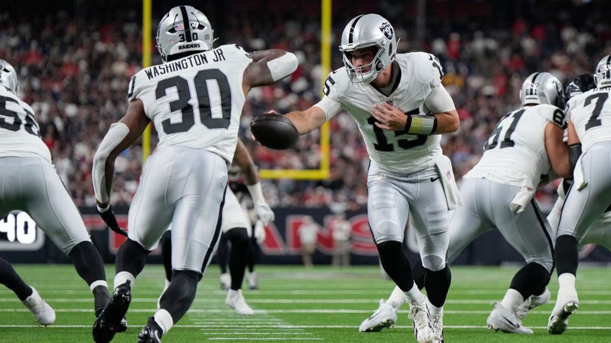 Las Vegas Raiders quarterback Fernando Mendoza (15) hands off to Las Vegas Raiders running back Mike Washington Jr. (30) during the first half of an NFL preseason football game against the Houston Texans, Thursday, Aug. 20, 2026, in Houston.