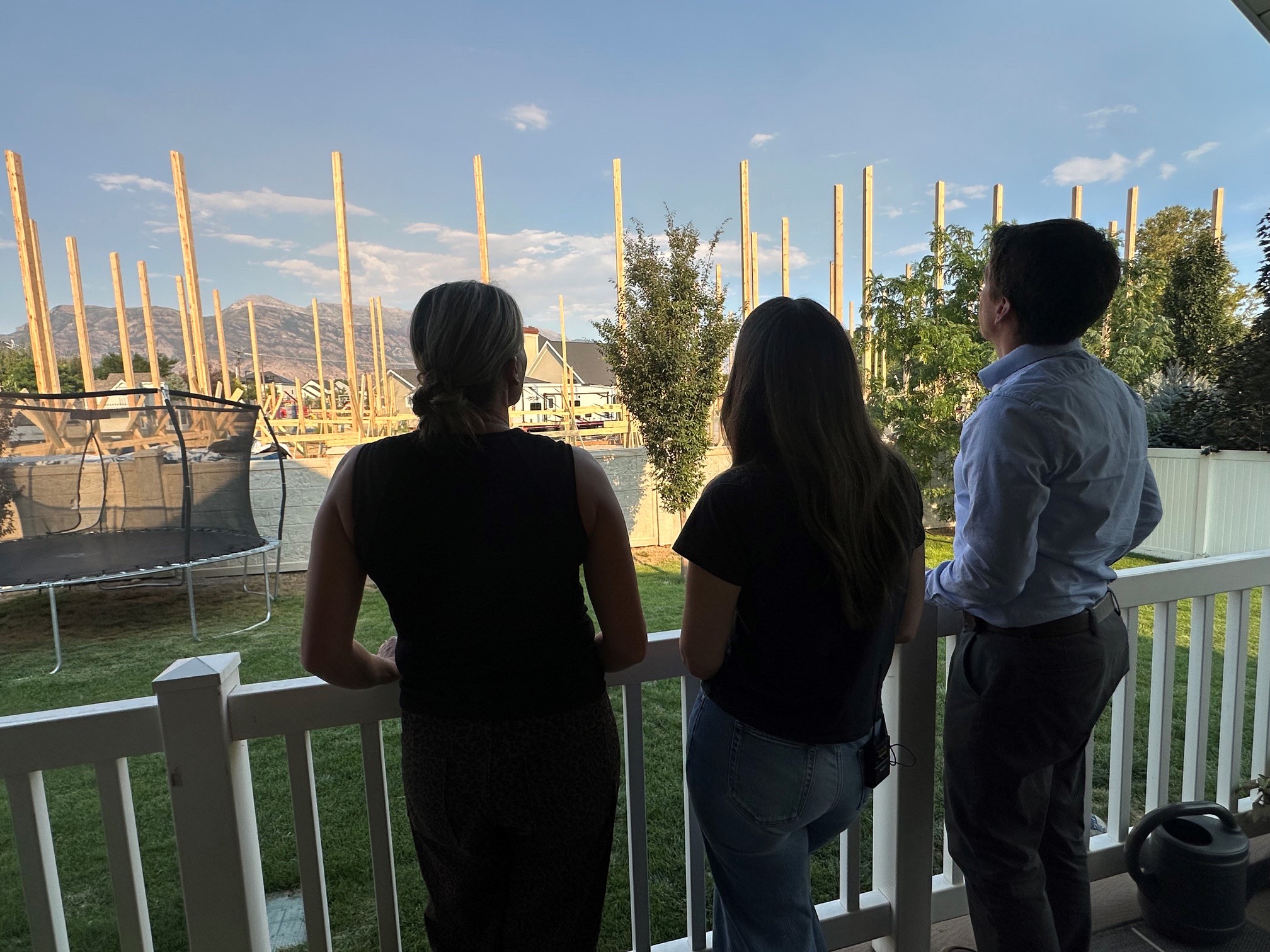 Dale Stewart and neighbors look at the construction project from their backyard deck on Tuesday.
