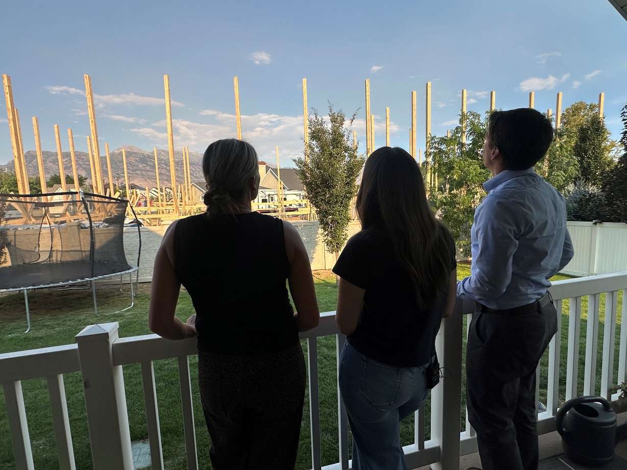 Dale Stewart and neighbors look at the construction project from their backyard deck on Tuesday.