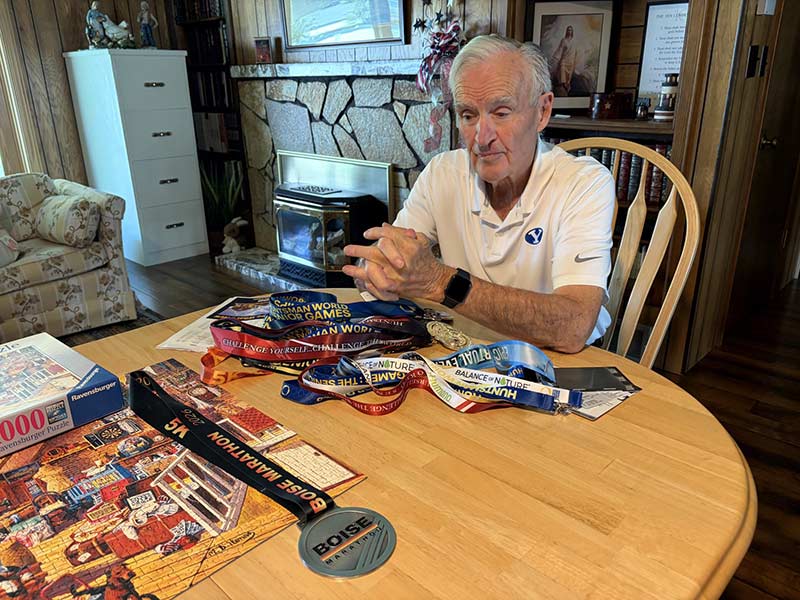 Noel Johnson at his home, looking at his 5K medals.
