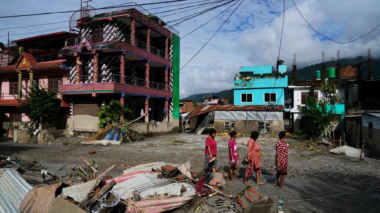 People walk past damage in the aftermath of flash floods in Devighat in the Nuwakot district in Nepal, Thursday, Aug 27, 2026.