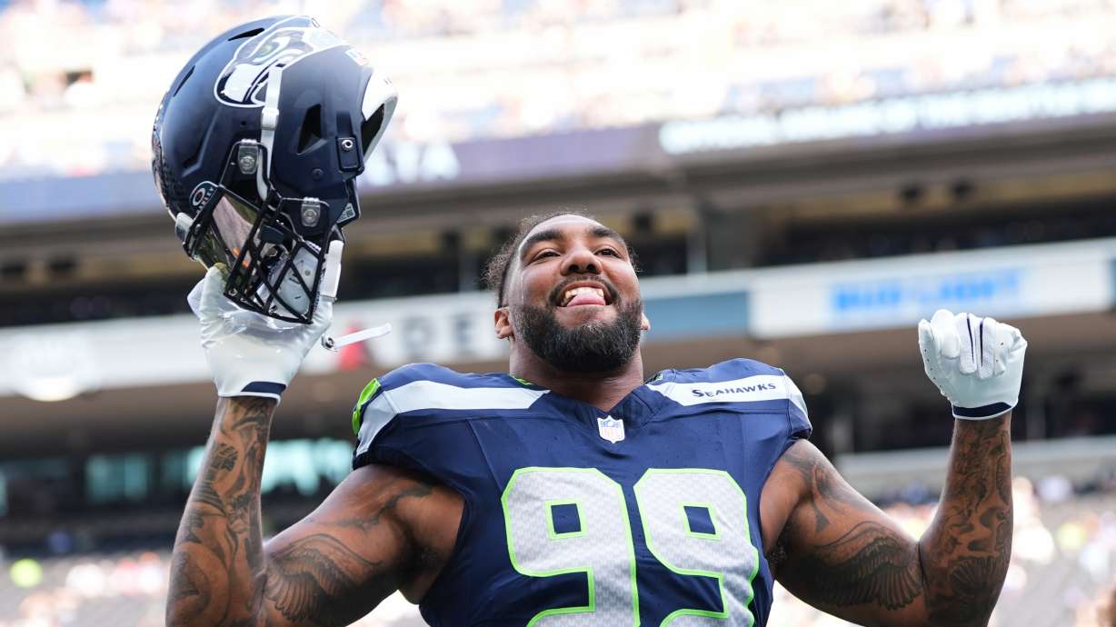 Seattle Seahawks' Leonard Williams responds to fans during warmups before an NFL preseason football game against the Dallas Cowboys, Saturday, Aug. 15, 2026, in Seattle.