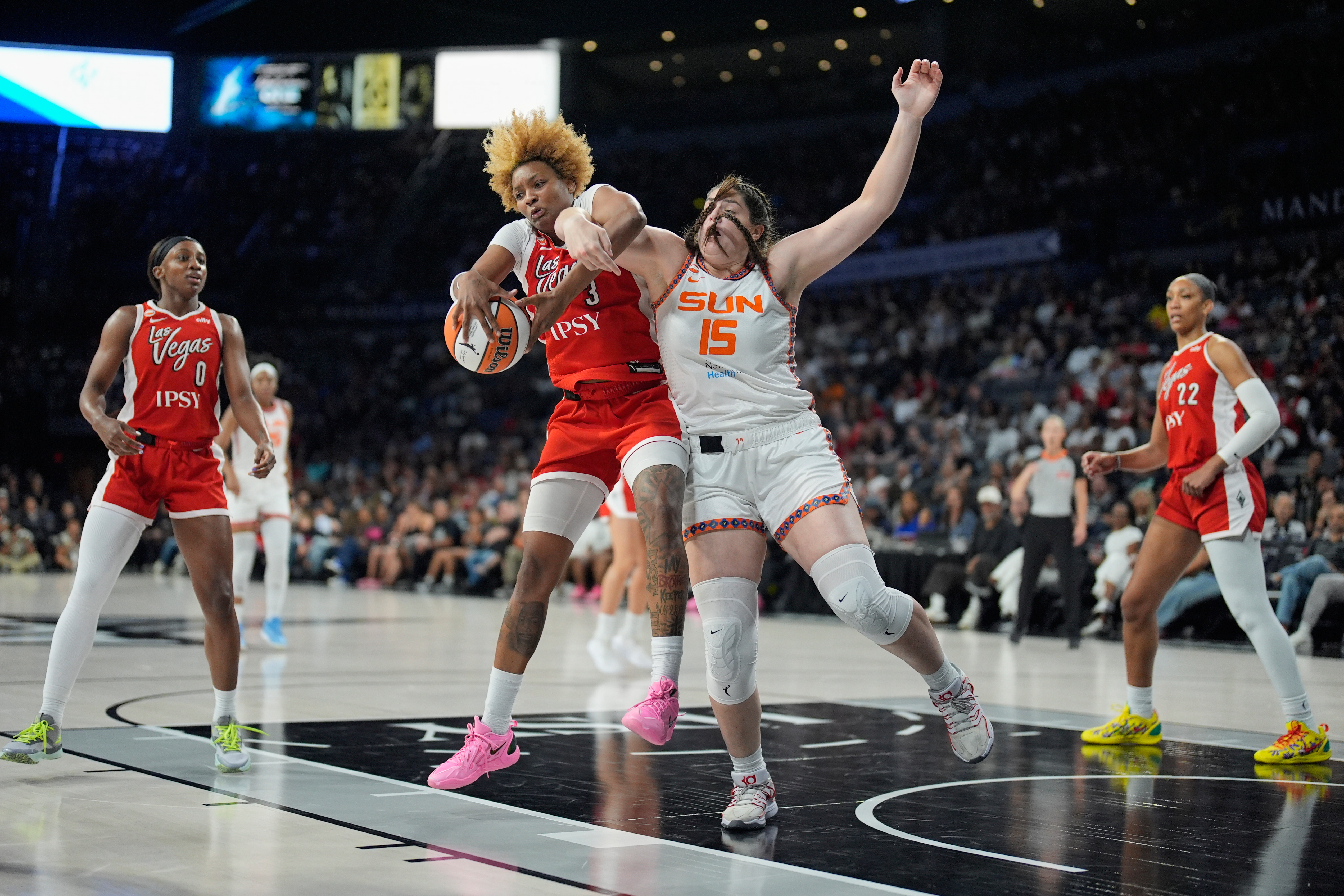 Las Vegas Aces forward NaLyssa Smith (3) and Connecticut Sun forward Raegan Beers (15) battle for the ball during the first half of a WNBA basketball game Thursday, Aug. 20, 2026, in Las Vegas. 