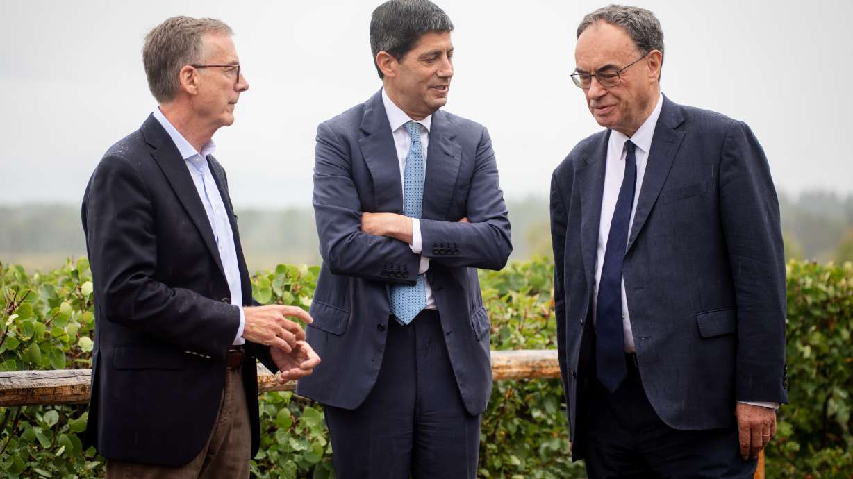 Fed Chair Kevin Warsh, center, talks to Bank of England Governor Andrew Bailey, right, and Bank of Canada Governor Tiff Macklem at the annual Jackson Hole Economic Policy Symposium on Friday, in Moran, Wyoming.