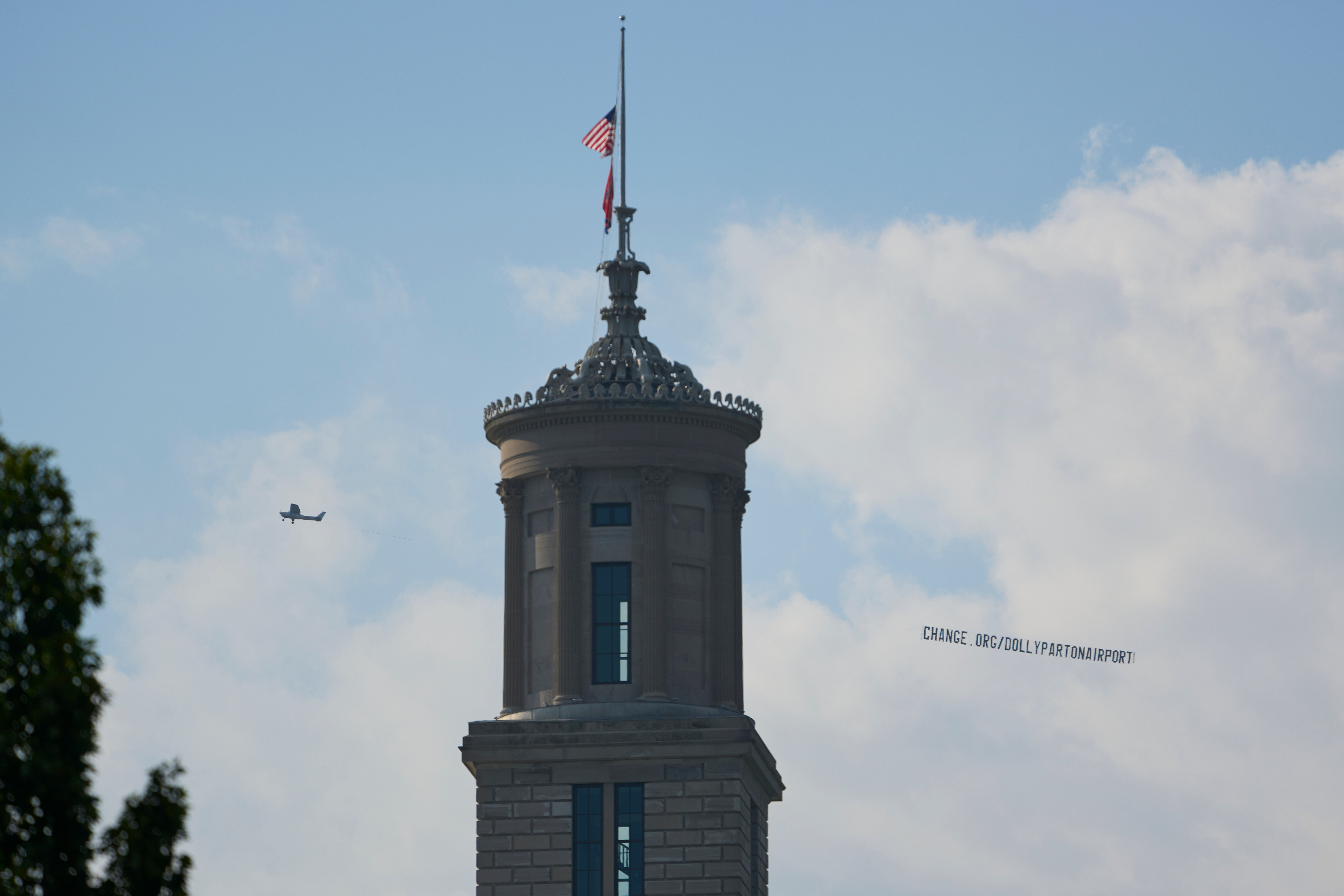 A plane flies over Nashville, Tenn., towing a banner reading “change.org/DollyPartonAirport” as part of an effort to rename the airport after Dolly Parton, Friday.