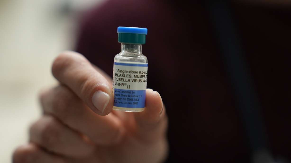 Dr. Jessica Early holds a vial of the combination measles, mumps and rubella vaccine at Prisma Health Pediatrics in Greer, S.C., March 18.