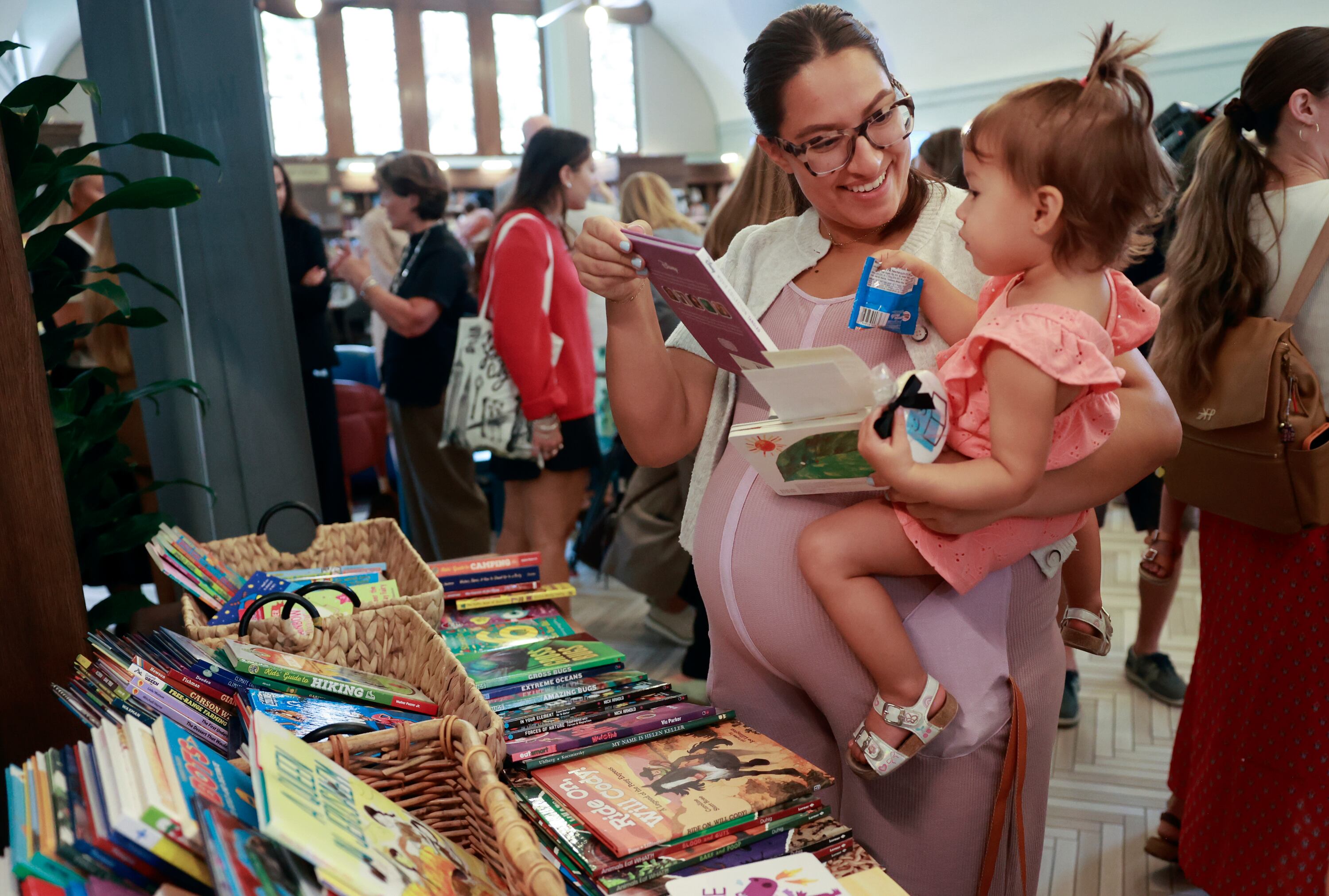 Ariel Webb holds her daughter Melody Rodriquez as they pick out a book at the launch of Utah Reads, a statewide early literacy initiative, at the Sprague branch of the Salt Lake City Public Library in Salt Lake City on Aug. 28.