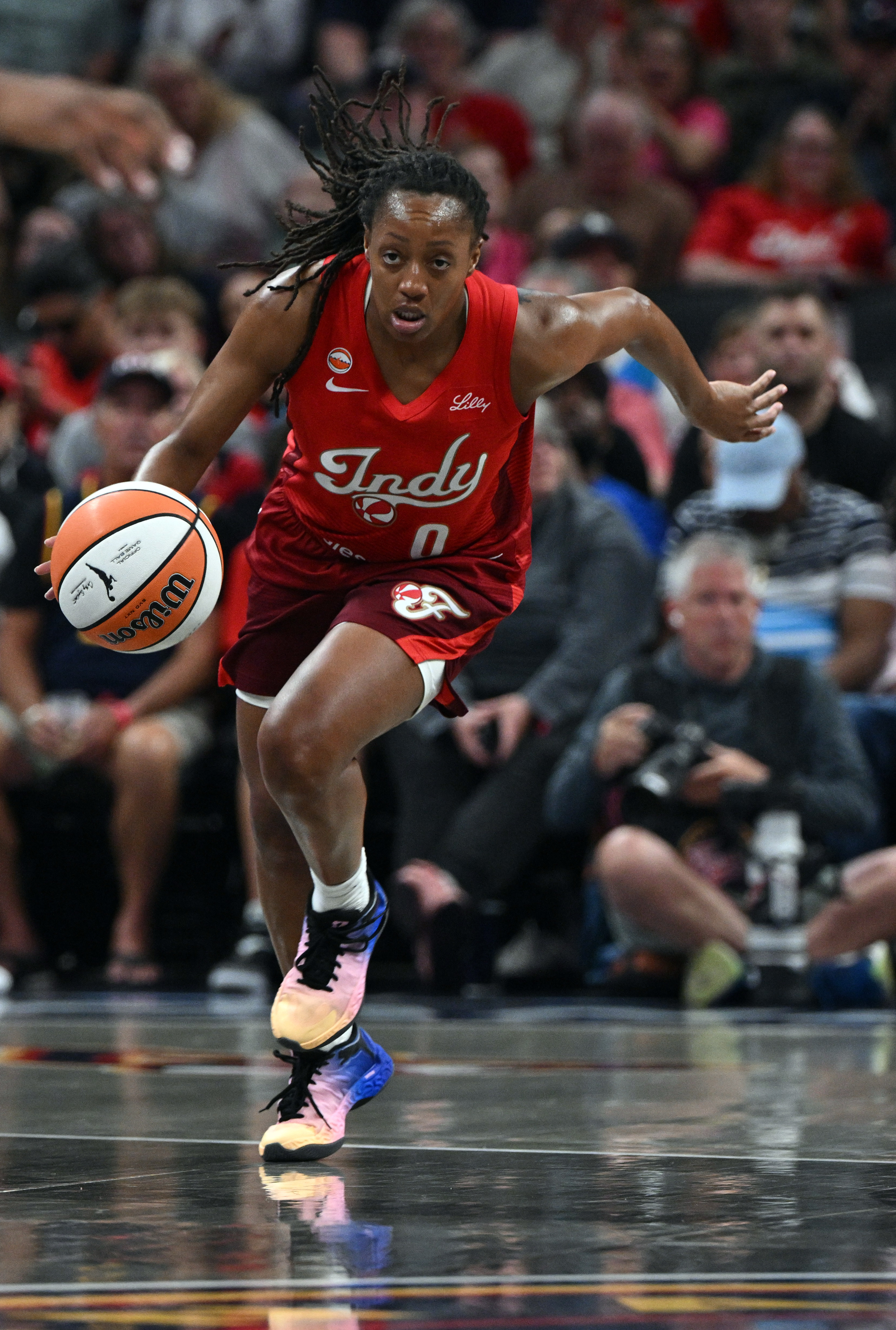 Indiana Fever guard Kelsey Mitchell (0) dribbles the ball down court during the first half of a WNBA basketball game against the Connecticut Sun, Friday, Aug. 28, 2026, in Indianapolis.