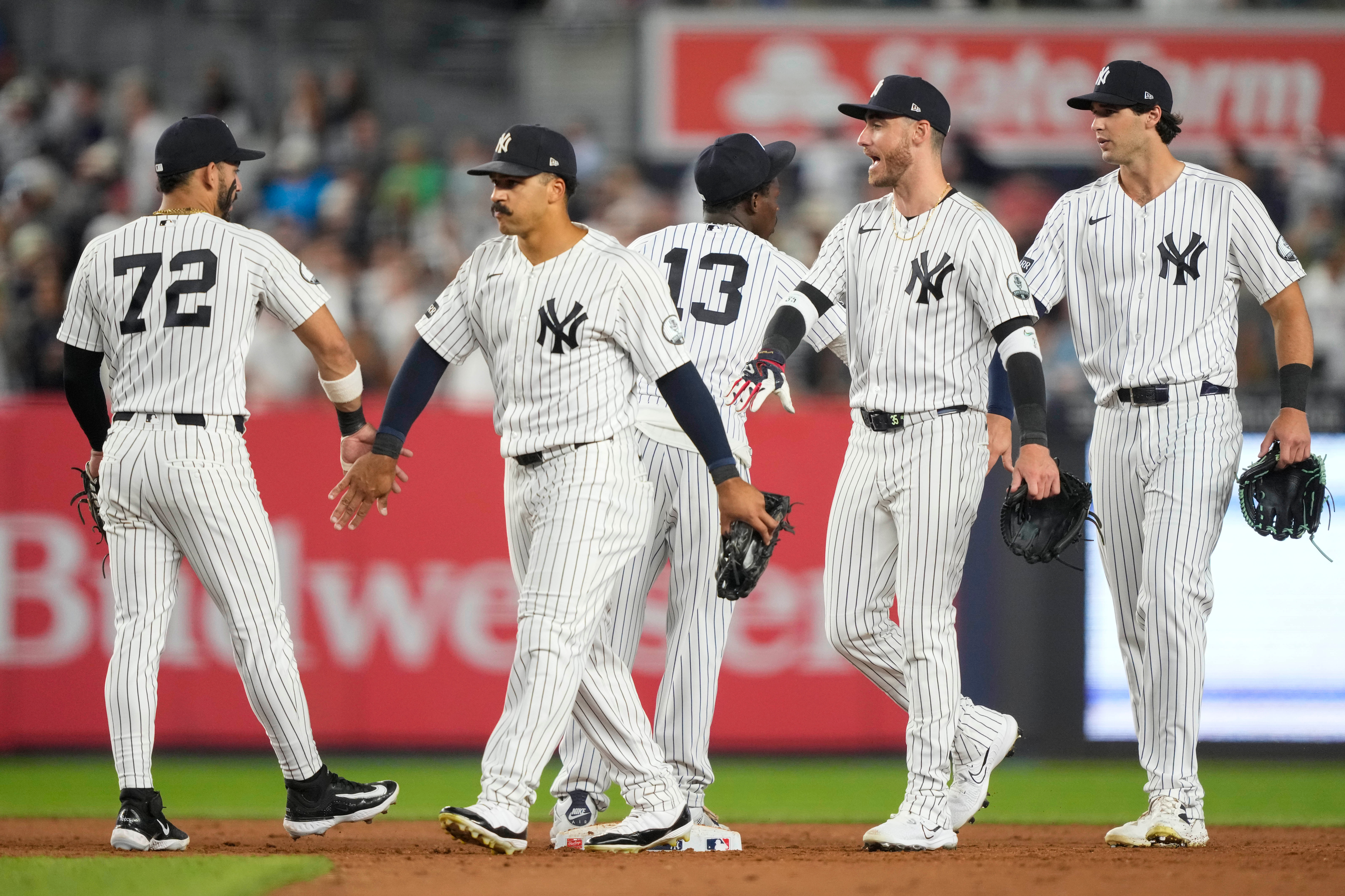 New York Yankees right fielder Spencer Jones, left fielder Cody Bellinger, and center fielder Trent Grisham, right to left, celebrate with teammates after winning a baseball game against the Boston Red Sox, Friday, Aug. 28, 2026, in New York.