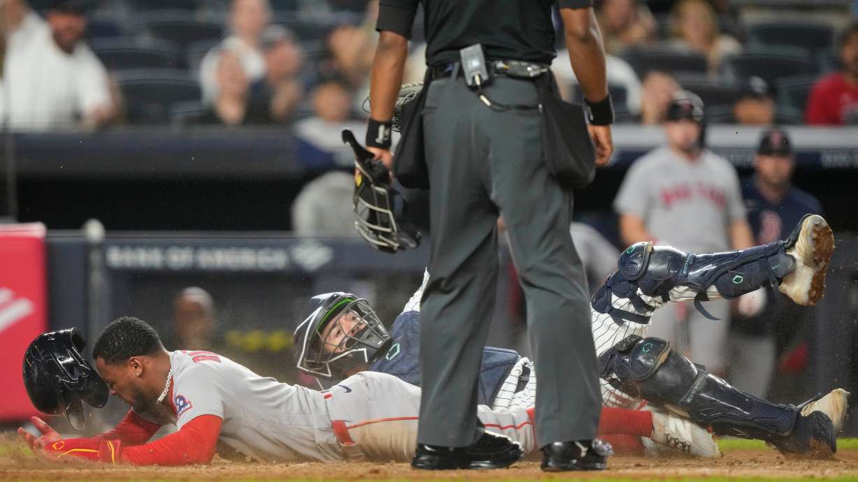 Boston Red Sox' Ceddanne Rafaela is tagged out by New York Yankees catcher Austin Wells at home plate on a double play during the seventh inning of a baseball game, Friday, Aug. 28, 2026, in New York.