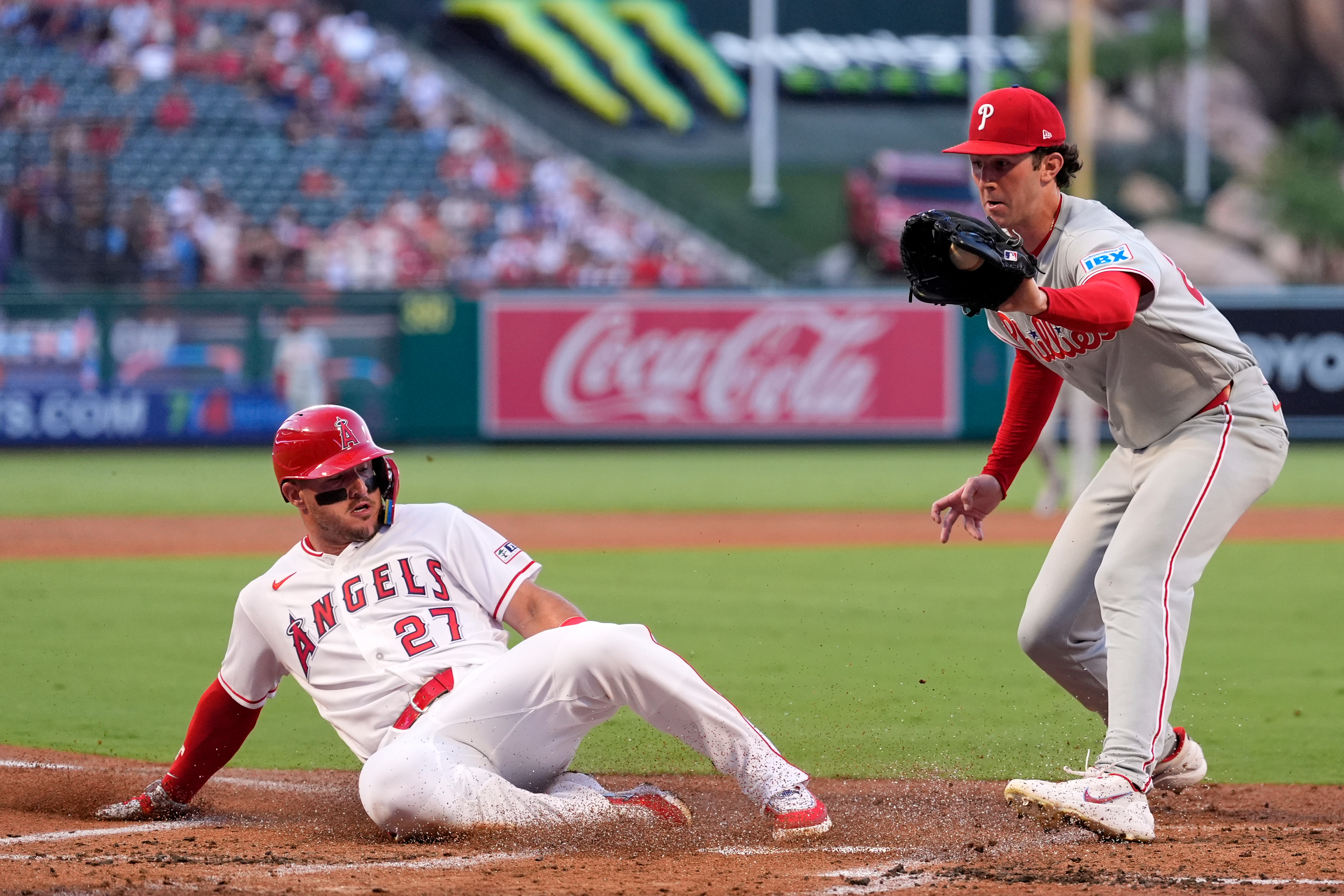 Los Angeles Angels' Mike Trout, left, scores on wild pitch by Philadelphia Phillies starting pitcher Andrew Painter, left, as Painter takes a late throw during the first inning of a baseball game Friday, Aug. 28, 2026, in Anaheim, Calif. 