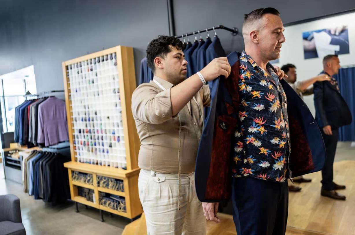 Ikani Iongi, assistant manager, left, fits Shane Hansen, right, for a suit for his wedding at H.M. Cole Custom Suits in Salt Lake City on Aug. 6.