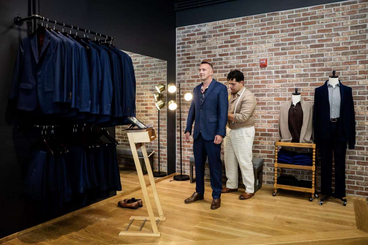 Ikani Iongi, assistant manager, right, fits Shane Hansen, left, for a suit for his wedding at H.M. Cole Custom Suits in Salt Lake City on Aug. 6.
