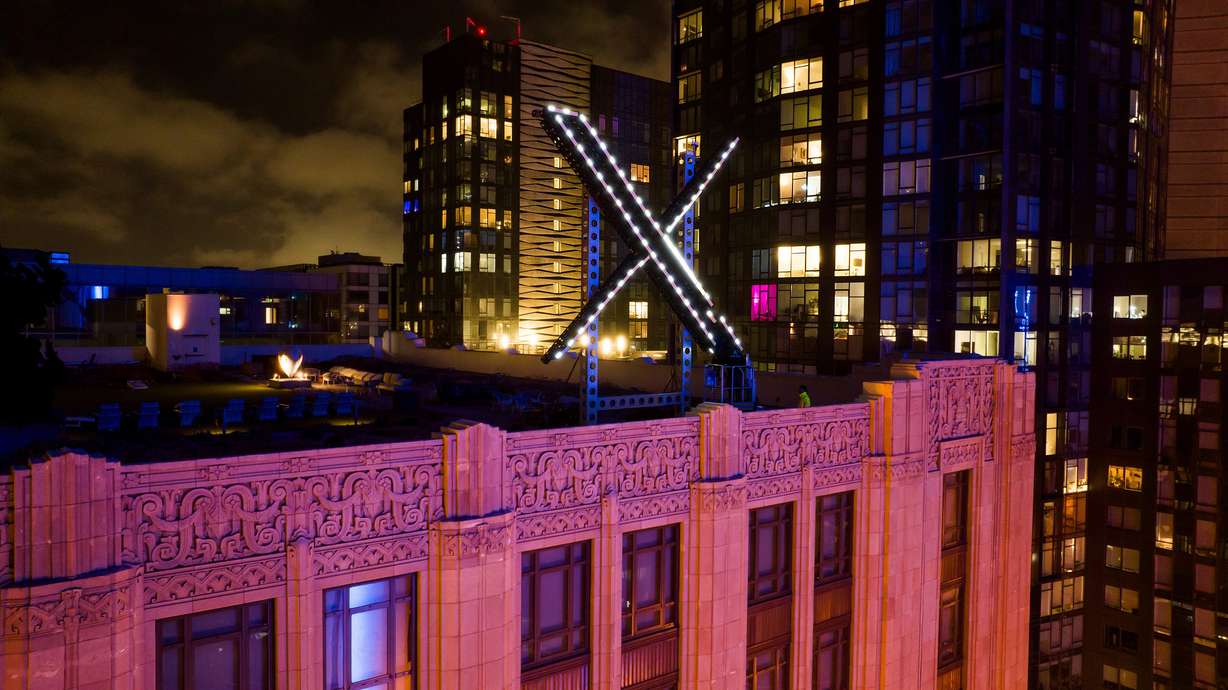 Workers install lighting on an "X" sign atop the company headquarters, formerly known as Twitter, in downtown San Francisco, July 28.
