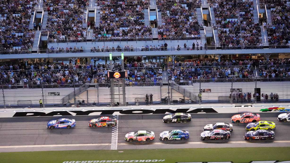 Kyle Larson (5) and Chase Briscoe (19) lead a group through the front stretch during early laps in the NASCAR auto race at Daytona International Speedway, Saturday, Aug. 29, 2026, in Daytona Beach, Fla.