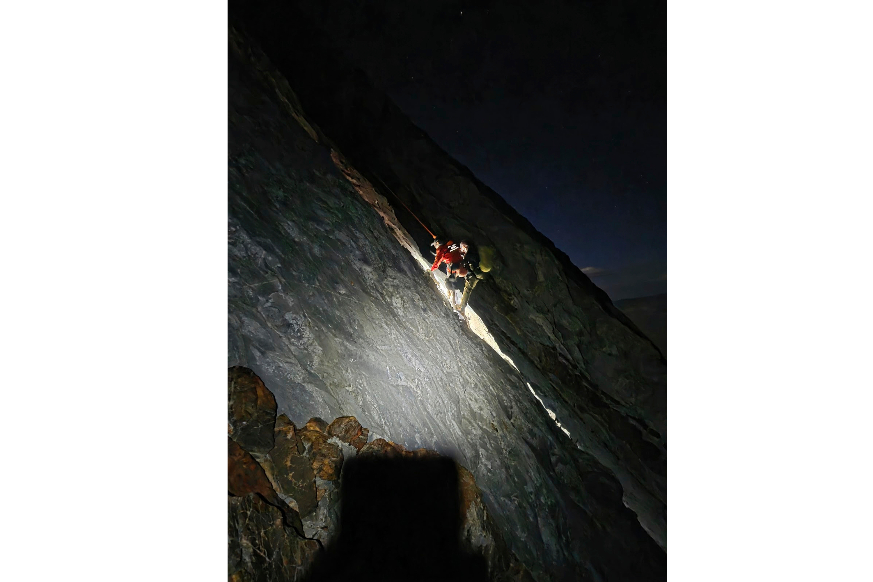 This photo released by Mono County Sheriff Search and Rescue, shows a rescuer with the man who was stranded, Rob Martin, right, after he was rescued on a ledge in the Sierra Nevada, Calif., on Aug. 22, 2026. 