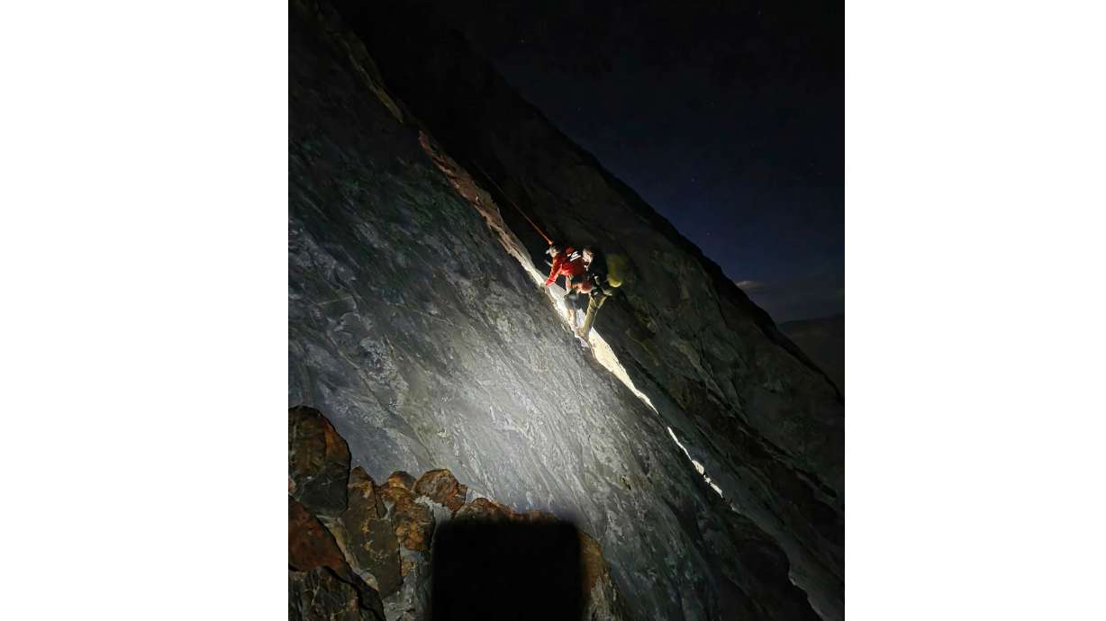 This photo released by Mono County Sheriff Search and Rescue, shows a rescuer with the man who was stranded, Rob Martin, right, after he was rescued on a ledge in the Sierra Nevada, Calif., on Aug. 22, 2026.