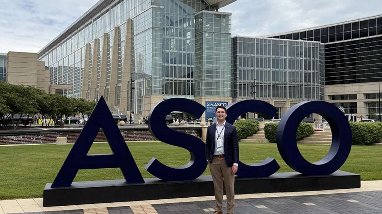 Daniel Thomas Jones in front of the ASCO sign at the 2026 American Society of Clinical Oncology Annual Meeting in Chicago, where he presented oncology research.