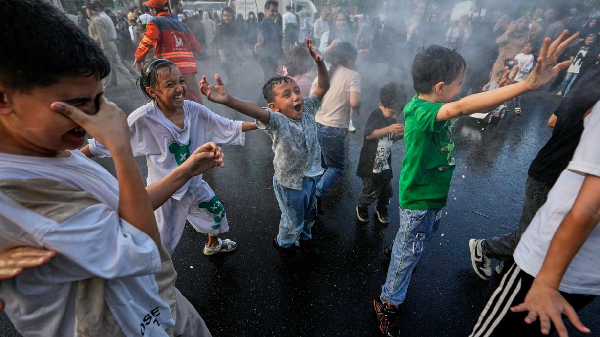 Children laugh and play in a spray of water during a street celebration marking Prophet Muhammad's birthday in Tehran, Iran, Sunday, Aug. 30, 2026.