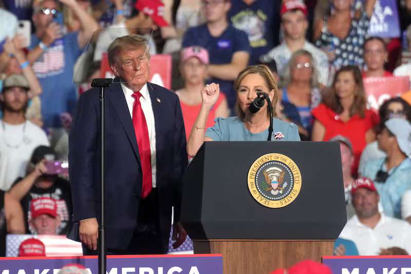 President Donald Trump, left, looks on as Sen. Darline Graham. R-S.C., speaks at a campaign rally as she competes in a special Republican primary to replace her brother, the late Sen. Lindsey Graham, R-S.C., Friday, Aug. 21, 2026, in Myrtle Beach, S.C.