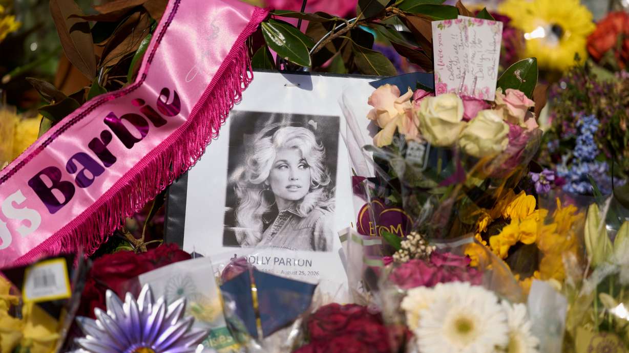 A portrait of the late Dolly Parton surrounded by flowers and cards in a memorial sits outside her home Thursday, in Brentwood, Tenn.