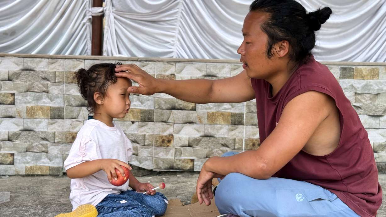 Survivor Tsering Gelbu Lama sits with his daughter at a monastery in Kathmandu, Nepal, Monday, Aug. 31, 2026.