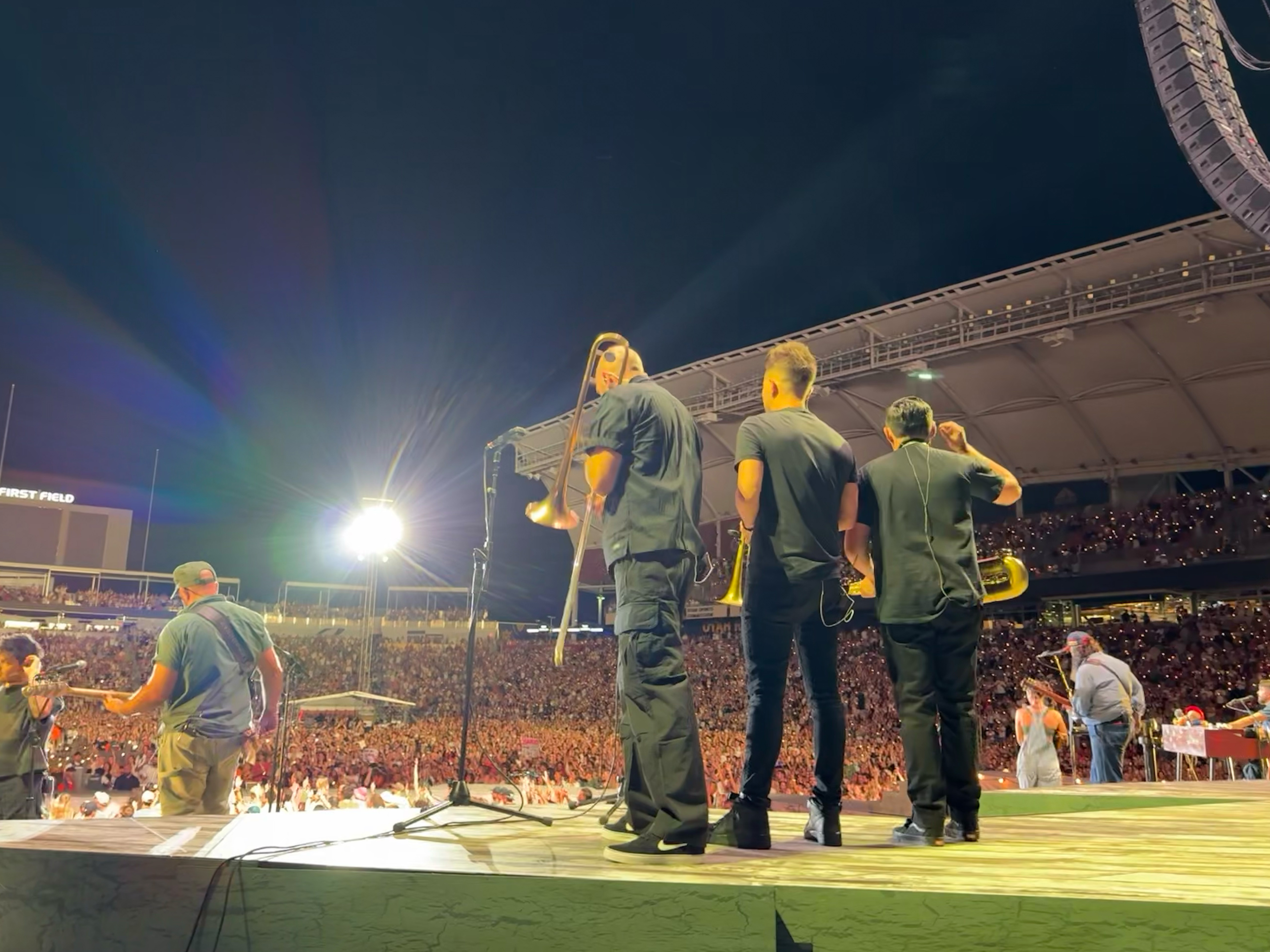 Trombonist Marcus Anderson (left), trumpeter Tom Young (middle) and saxophonist Candido Abeyta are pictured standing in front of a 25,000-strong crowd at America First Field during Noah Kahan's performance in Utah on Tuesday, Aug. 25.