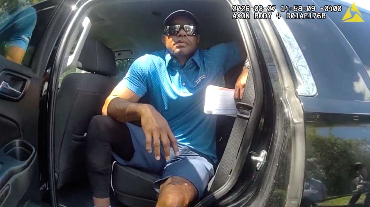 FILE - In this image from police body camera video released by the Martin County, Fla., Sheriff's Office, golfer Tiger Woods sits in an unmarked police vehicle as he speaks with law enforcement personnel following a car crash in Jupiter Island, Fla., March 27, 2026.