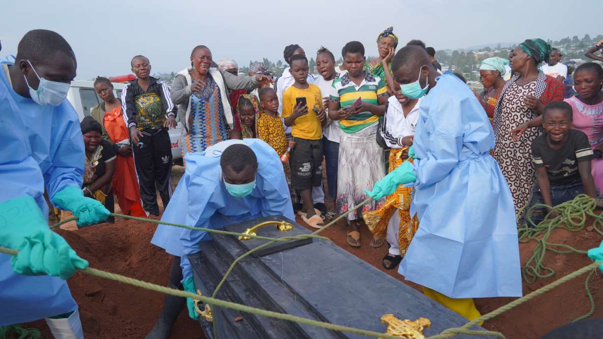 People dressed in protective gear lower into a grave the coffin containing the remains of Jeannine Katusabe, who died of Ebola, during a burial service in Bunia, Ituri province, eastern Congo, Aug. 11. Government data on Tuesday showed the outbreak has claimed over 3,000 lives.