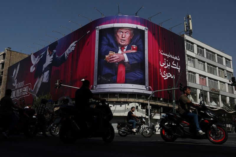 People drive near a billboard depicting President Donald Trump on a building in Tehran, Iran, Wednesday. Iran and the U.S. exchanged their heaviest fire since July overnight Tuesday.