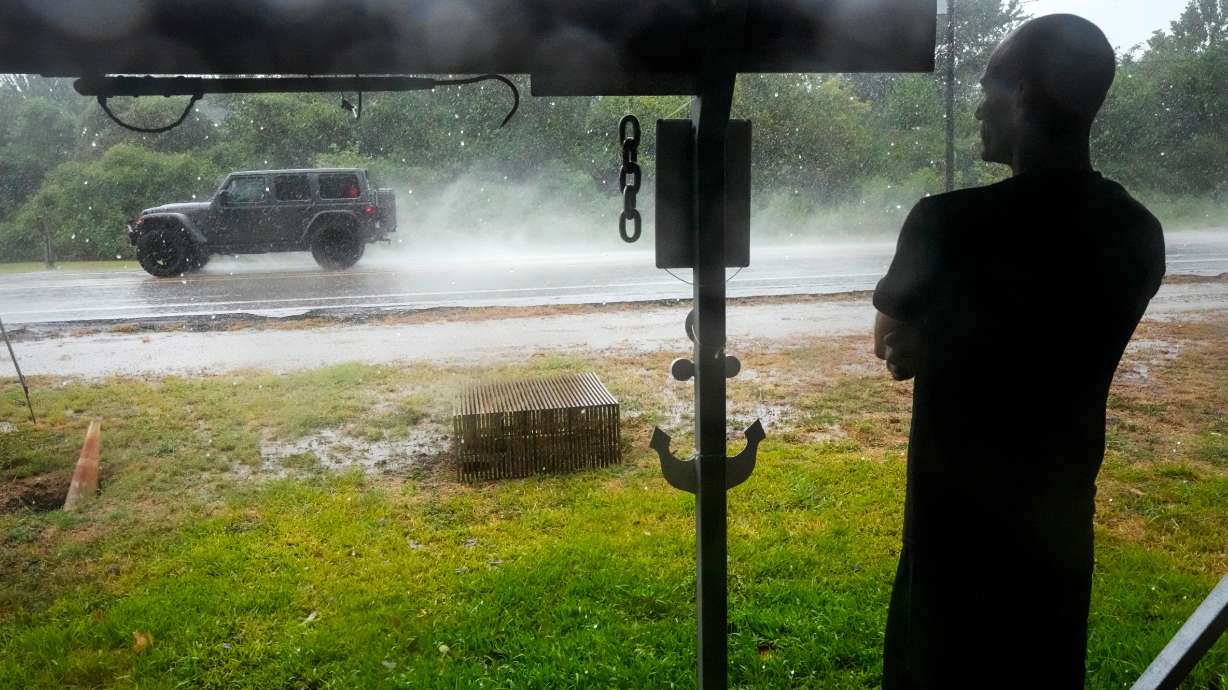 Michael Espinoza stands under the awning of his shop, T&M Bait Shop, watching rain from Tropical Storm Edouard come down in High Island, Texas, on Tuesday, Sept. 1, 2026.