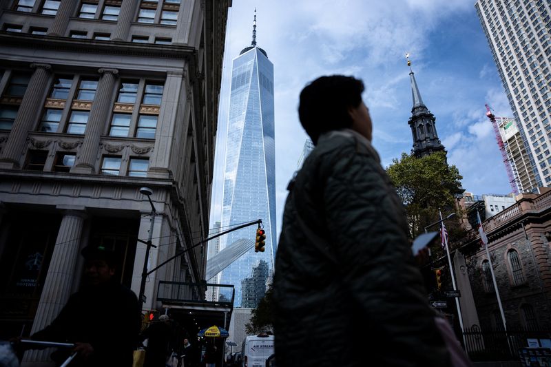 People walk around the Financial District in New York City, U.S., November 5, 2025.