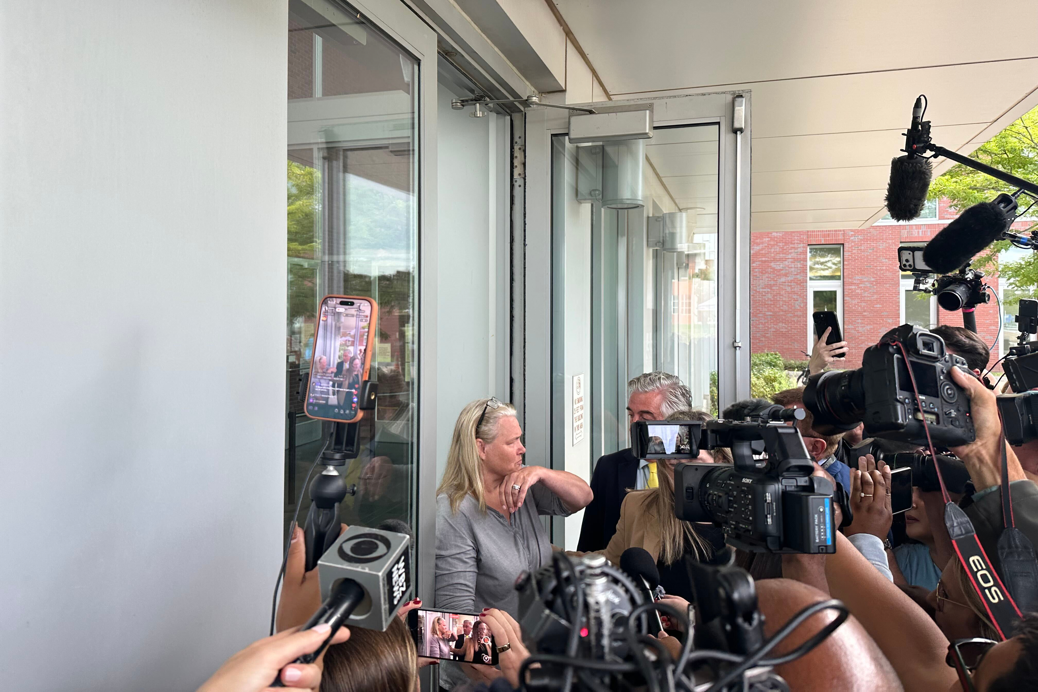 Dawn Light is questioned by reporters as she leaves her arraignment where she was charged with intimidation in connection with the Lindsay Clancy's murder trial in Plymouth, Mass., Wednesday. Light was arrested on Tuesday for allegedly filming the courthouse.