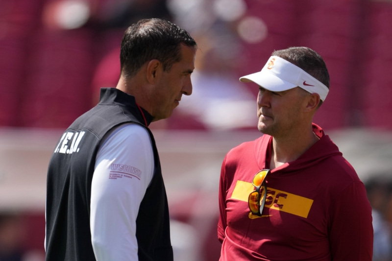 Sep 28, 2024; Los Angeles, California, USA; Wisconsin Badgers head coach Luke Fickell (left) talks with Southern California Trojans head coach Lincoln Riley before a game at United Airlines Field at Los Angeles Memorial Coliseum.