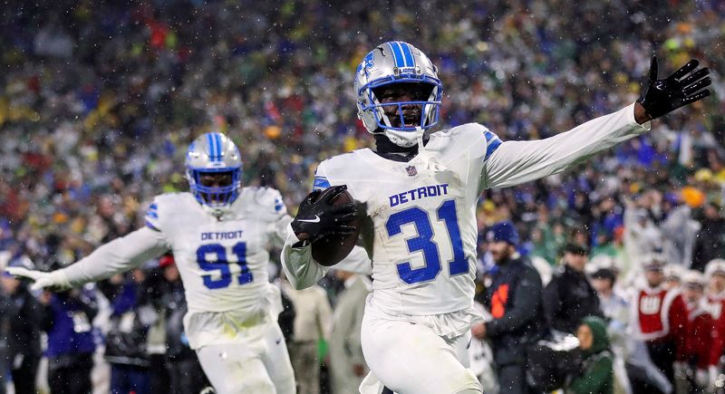 Nov 3, 2024; Green Bay, Wisconsin, USA; Detroit Lions safety Kerby Joseph (31) returns an interception for a touchdown near the end of the first half against the Green Bay Packers at Lambeau Field.