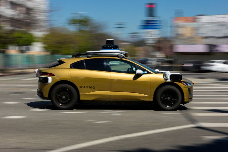 FILE PHOTO: A golden painted Waymo driverless vehicle drives down a street in Los Angeles, California, U.S., March 18, 2026.