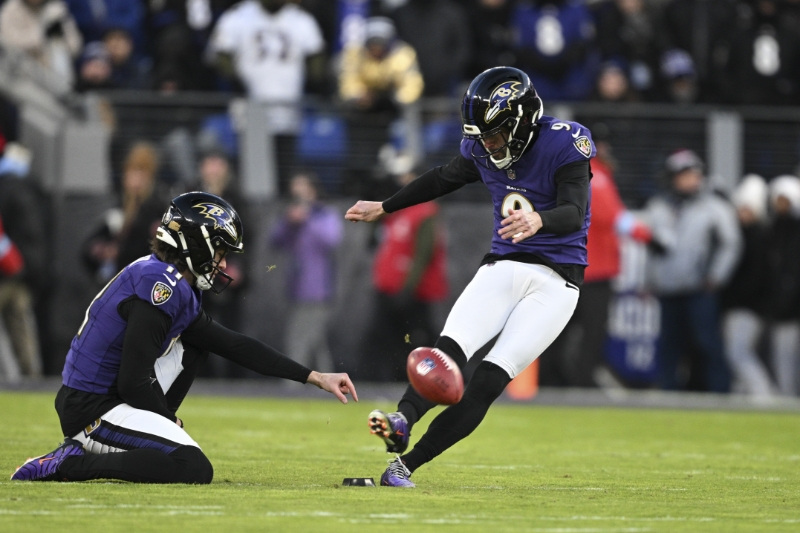 FILE PHOTO: Jan 4, 2025; Baltimore, Maryland, USA;  Baltimore Ravens place kicker Justin Tucker (9) kicks off as  punter Jordan Stout (11) holds during the first quarter against the Cleveland Browns at M&T Bank Stadium.