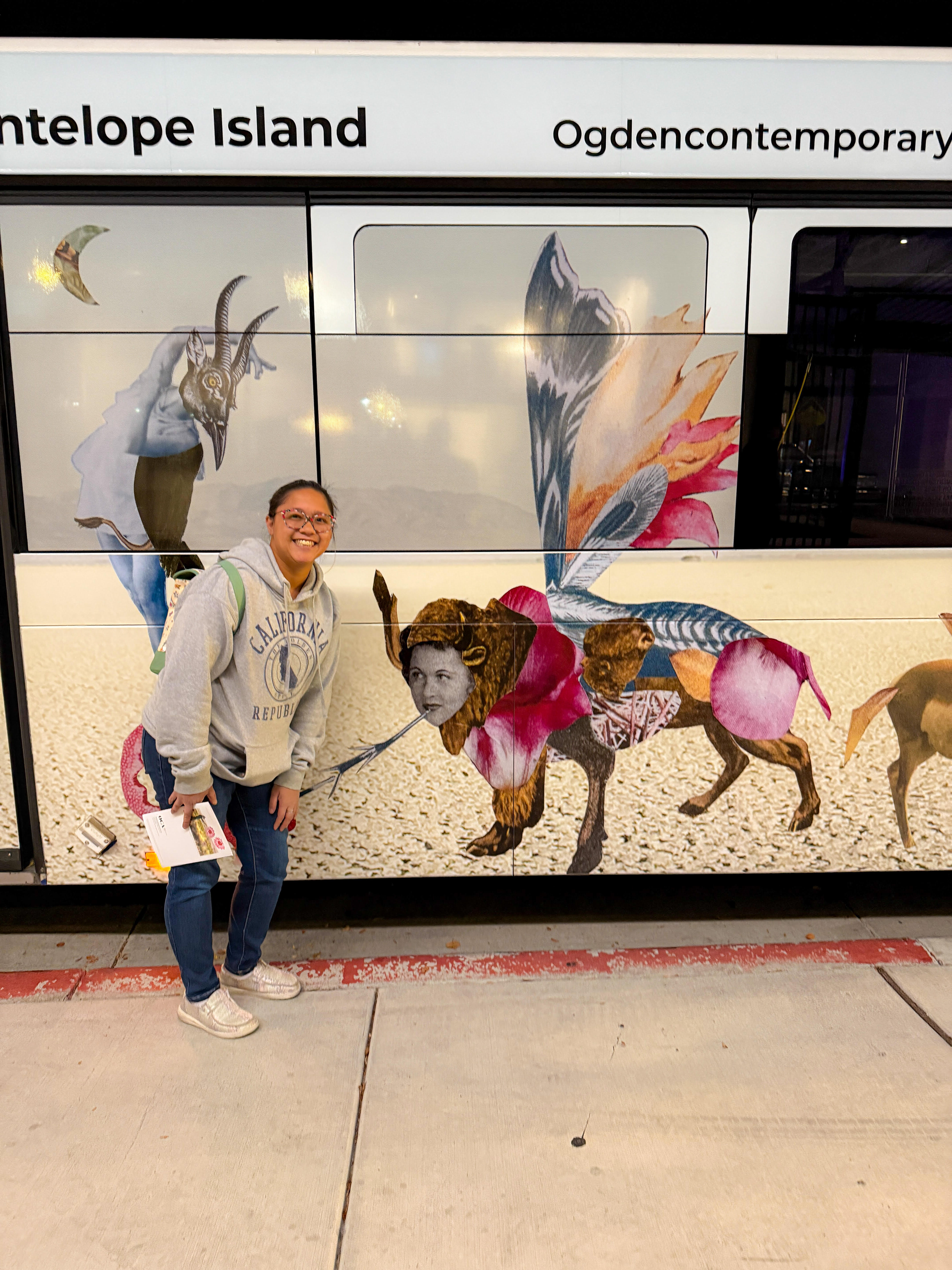 Tawni Jae Sherlock poses next to her painting, "Betsy," as it's displayed on the side of a public bus in Ogden.